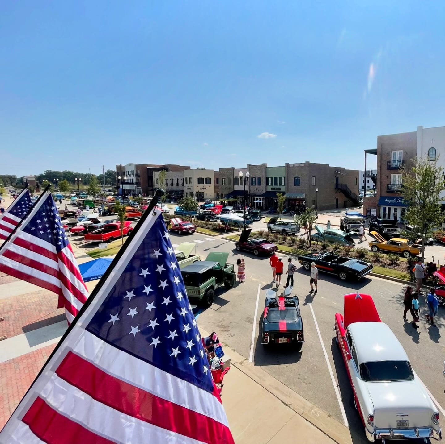Classic cars gathered at a Cars for a Cause event beside a silo in Southaven